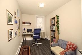 Winnipeg apartment for rent - A cozy room with a couch, chair, and bookshelf.