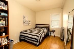 Winnipeg apartment for rent - A bedroom with a bed, a window, and a bookshelf.