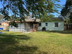 Orlando house for rent - A house with a green lawn and trees in the background.