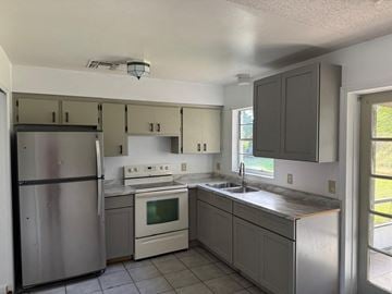Orlando house for rent - A kitchen with a refrigerator, stove, and sink.
