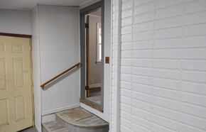 Lima house for rent - A white door with a wooden frame is open to a hallway.