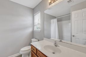 Pooler house for rent - A white toilet sits next to a white sink in a bathroom.