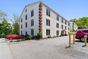 Phoenixville apartment for rent - A white building with a red car parked in front.