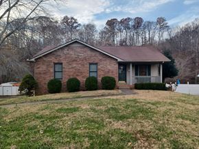 Clarksville house for rent - A brick house with a brown roof and a white fence.