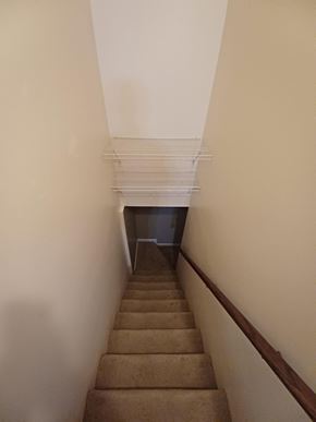 Clarksville house for rent - A staircase with a carpeted runner and a metal handrail.