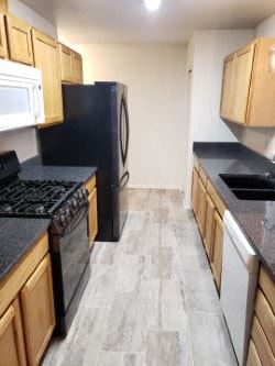 Anchorage house for rent - A kitchen with a black fridge and a black stove top.