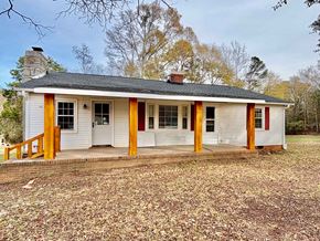 Piedmont house for rent - A small white house with a grey roof and a red door.
