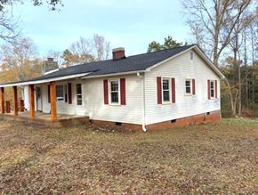 Piedmont house for rent - A white house with red trim and a black roof.