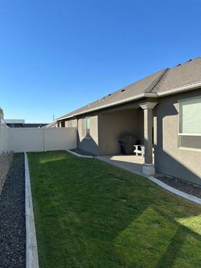 Pasco house for rent - A house with a grey roof and a green lawn.