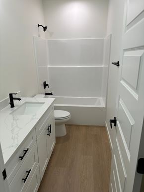Benton City house for rent - A white bathroom with a toilet, sink, and bathtub.