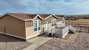 Walsenburg house for rent - A house with a brown siding and a brown roof with a white trim.
