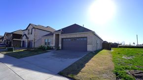 Forney house for rent - A house with a garage and a driveway in front of it.