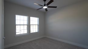Forney house for rent - A room with a ceiling fan and two windows.