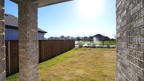 Forney house for rent - A backyard with a wooden fence and a grassy area.