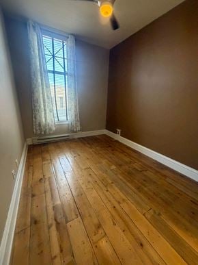Grinnell apartment for rent - A room with wooden flooring and a window with a curtain.