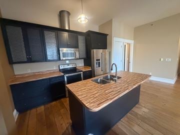 Grinnell apartment for rent - A kitchen with black cabinets and a wooden countertop.