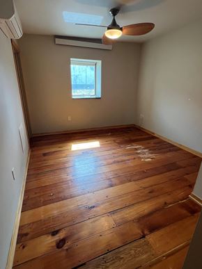 Grinnell apartment for rent - A room with wooden floors and a ceiling fan.