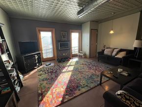 Grinnell apartment for rent - A living room with a couch, a rug, and a television.