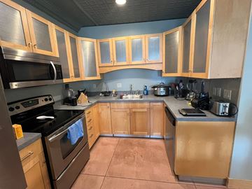 Grinnell apartment for rent - A kitchen with wooden cabinets and a black stove top.