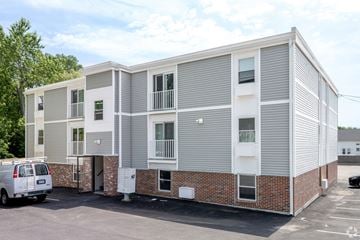 West Warwick apartment for rent - A white van is parked in front of a two-story apartment building.
