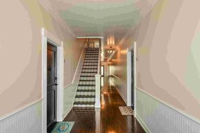 Tampa apartment for rent - A hallway with a staircase and a chandelier.