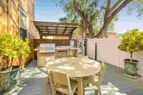 Tampa apartment for rent - A patio with a table and chairs is surrounded by potted plants.