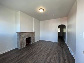 Glassport house for rent - A room with a fireplace and wood flooring.