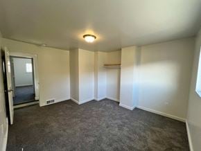 Glassport house for rent - A room with a grey carpet and white walls.