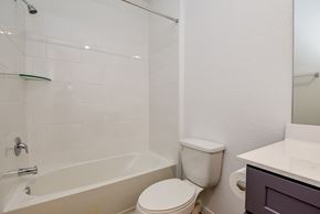 Katy house for rent - A white bathroom with a toilet, sink, and bathtub.