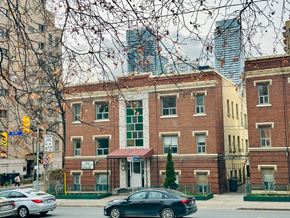 Toronto apartment for rent - A black car is parked in front of a brick building.