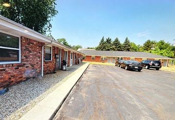 Fremont apartment for rent - A parking lot with cars and a building with a brick wall.