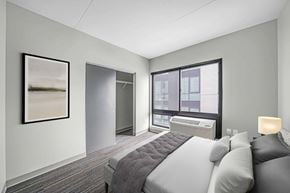 Philadelphia apartment for rent - A bedroom with a bed, pillows, a window, and a painting on the wall.