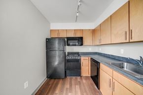 Philadelphia apartment for rent - A kitchen with wooden cabinets and black appliances.