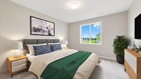 Hastings house for rent - A bedroom with a large bed and a window showing a view of a green landscape.
