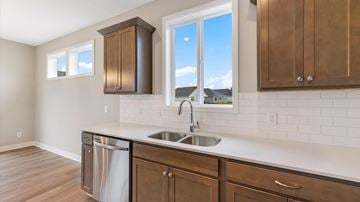 Hastings house for rent - A kitchen with a stainless steel dishwasher and a white countertop.