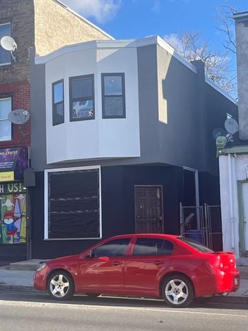 Philadelphia apartment for rent - A red car is parked in front of a black and white building.