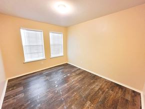 Temple house for rent - A room with wooden flooring and two windows.