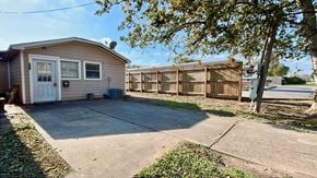 Sweeny house for rent - A small house with a white door and a brown fence.