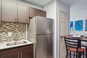 Philadelphia apartment for rent - A kitchen with a stainless steel refrigerator and a sink with a brown cabinet.