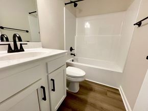 Louisville house for rent - A white bathroom with a toilet, sink, and a shower.