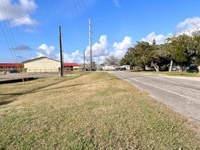 Bay City house for rent - A grassy field with a building and power lines in the background.