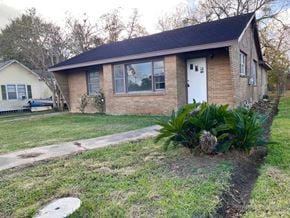 Bay City house for rent - A small house with a white door and a small garden in front.