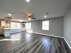 Bay City house for rent - A spacious room with a ceiling fan and wooden flooring.
