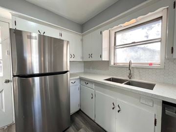 Bay City house for rent - A kitchen with a stainless steel refrigerator and white cabinets.