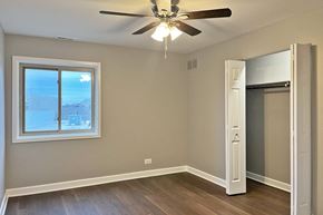Forest Park apartment for rent - A room with a ceiling fan and a window overlooking a snowy landscape.