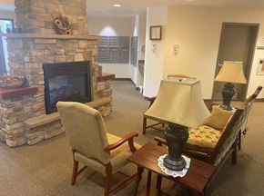 Longmont apartment for rent - A living room with a stone fireplace and a chair.