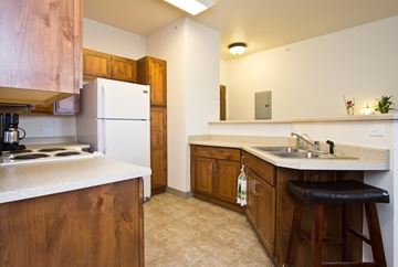 Longmont apartment for rent - A kitchen with wooden cabinets and a white fridge.