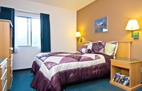 Longmont apartment for rent - A bedroom with a bed, nightstand, and window.