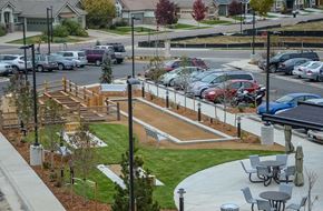 Longmont apartment for rent - A parking lot with cars and a playground.