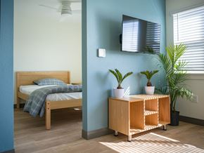 Longmont apartment for rent - A bedroom with a bed, a nightstand, and a plant.